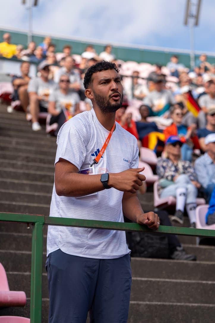 Hamed Lantih en tribune, en train de coacher pendant une compétition internationale d'athlétisme